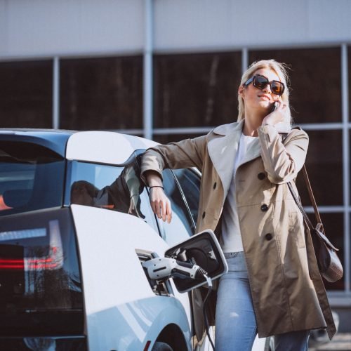 woman-charging-electro-car-electric-gas-station-min